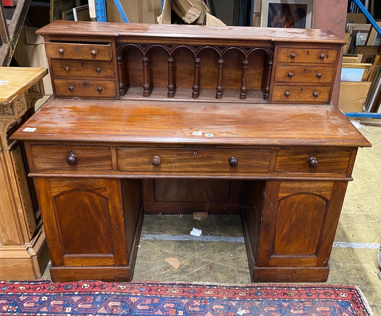 A Victorian style hardwood kneehole desk with galleried superstructure, length 140cm, depth 64cm, height 112cm